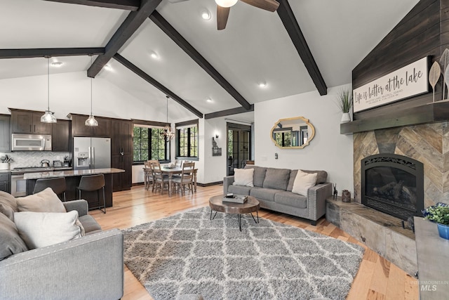 1520 Roosevelt Ave, Mccall, ID 83638 - living area with light wood finished floors, a ceiling fan, a large fireplace, beamed ceiling, and recessed lighting