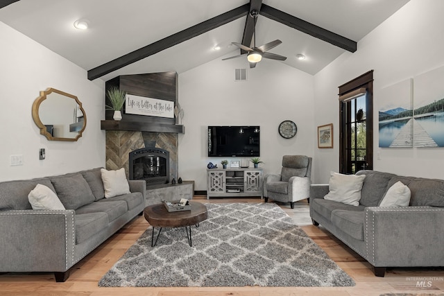 1520 Roosevelt Ave, Mccall, ID 83638 - living room featuring light wood-style flooring, beamed ceiling, a ceiling fan, a large fireplace, and high vaulted ceiling