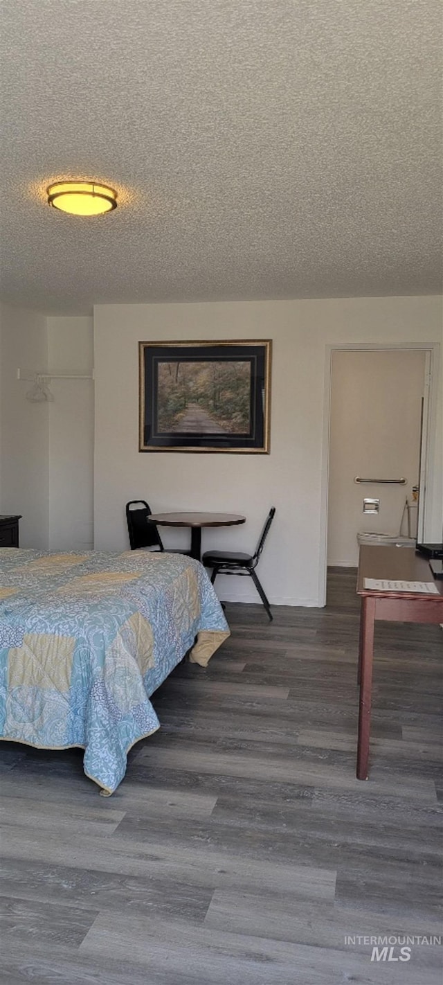 bedroom with a textured ceiling and hardwood / wood-style flooring