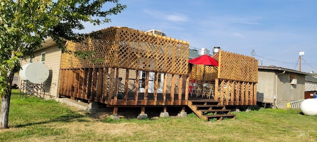 rear view of property featuring a deck and a yard