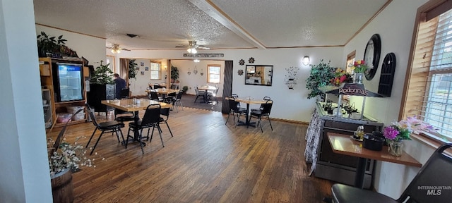 dining space with ceiling fan, dark hardwood / wood-style floors, plenty of natural light, and a textured ceiling