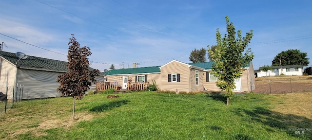 rear view of property featuring a lawn