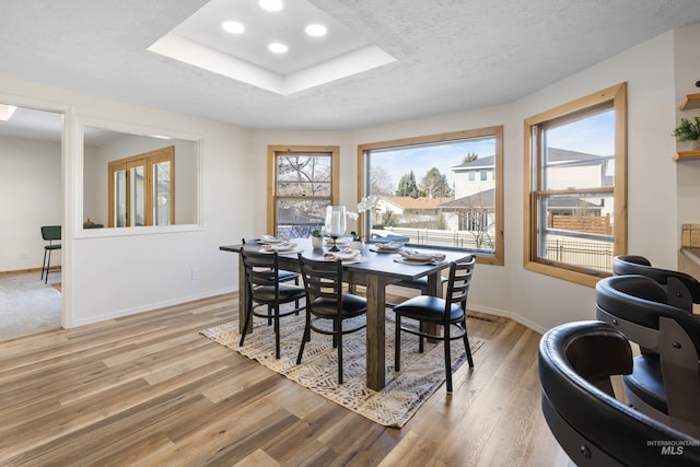 dining area with recessed lighting, baseboards, a textured ceiling, and light wood-style flooring