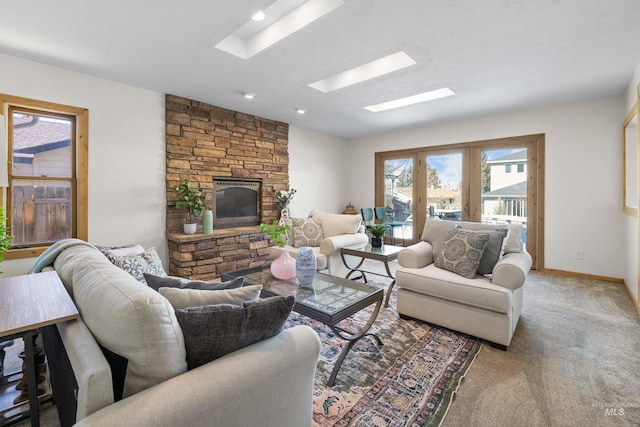 living area with french doors, carpet floors, a skylight, a fireplace, and baseboards