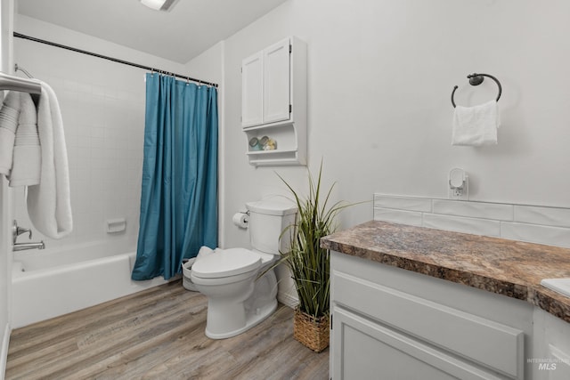 bathroom featuring toilet, vanity, shower / tub combo, and wood finished floors