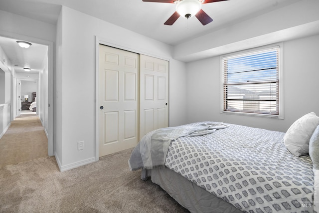 bedroom with a closet, baseboards, carpet, and a ceiling fan