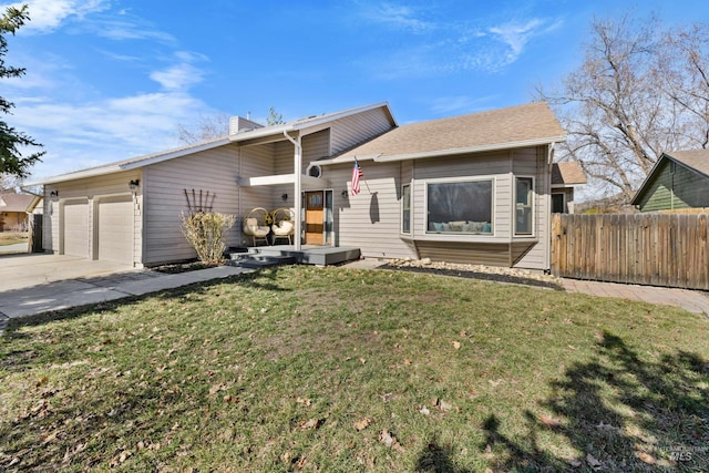 view of front of house featuring a front lawn, fence, a chimney, driveway, and an attached garage