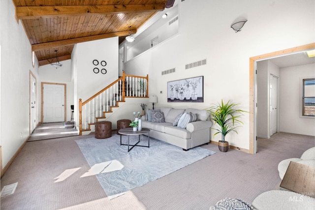 carpeted living area featuring stairs, beamed ceiling, wood ceiling, and visible vents