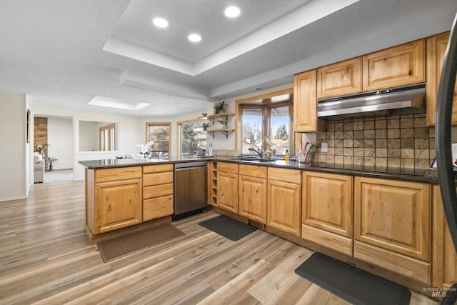 kitchen with a peninsula, under cabinet range hood, dishwasher, dark countertops, and black electric cooktop