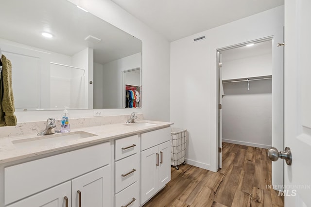 11002 W Hidden Point St, Star, ID 83669 - full bathroom with wood finished floors, a shower, double vanity, a spacious closet, and baseboards