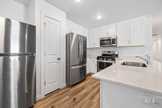 11002 W Hidden Point St, Star, ID 83669 - kitchen with stainless steel appliances, a sink, light wood-type flooring, white cabinetry, and recessed lighting