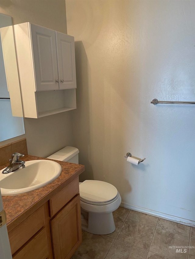 bathroom featuring tile patterned floors, toilet, and vanity