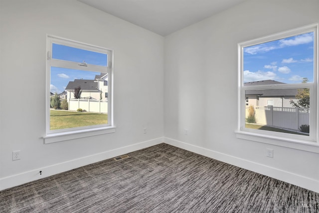 unfurnished room featuring baseboards, visible vents, and carpet floors