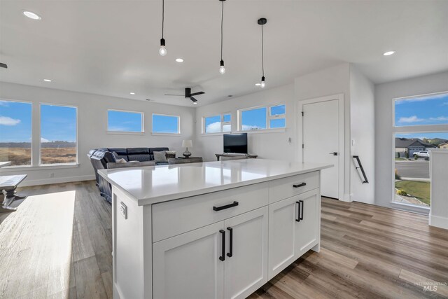 kitchen featuring pendant lighting, white cabinets, light wood-type flooring, and ceiling fan