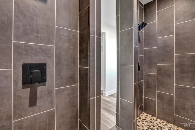 details with wood-type flooring and tiled shower