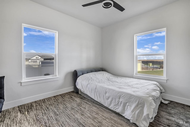 bedroom with ceiling fan and baseboards