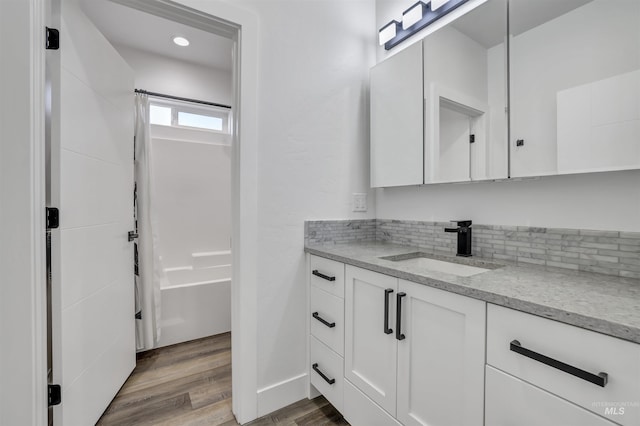 full bathroom with tasteful backsplash, wood finished floors, recessed lighting, vanity, and shower / tub combo with curtain