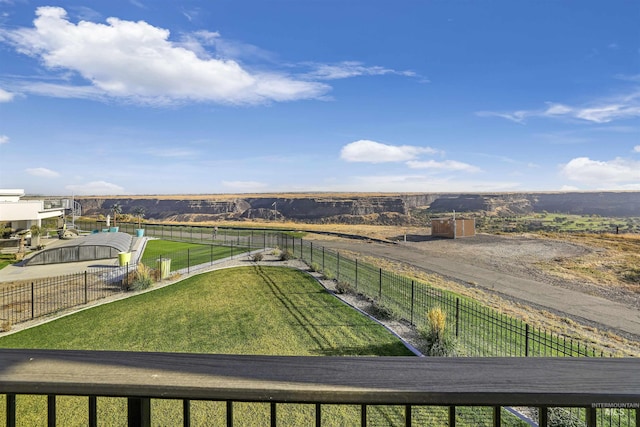 view of yard with fence and a rural view