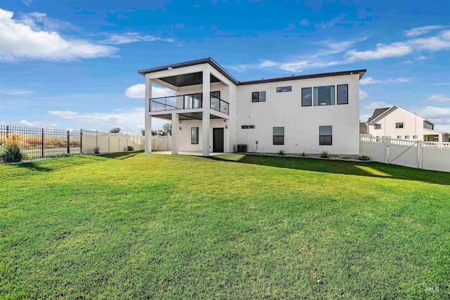 back of house with a yard, a balcony, and central AC