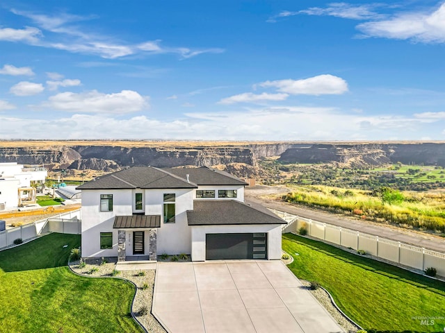 view of front of house featuring a front lawn, a mountain view, and a garage