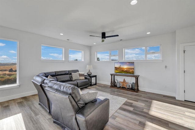 living room with light wood-type flooring, a wealth of natural light, and ceiling fan