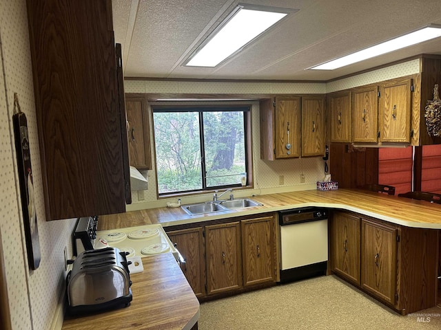 kitchen featuring a textured ceiling, dishwasher, cooktop, and sink