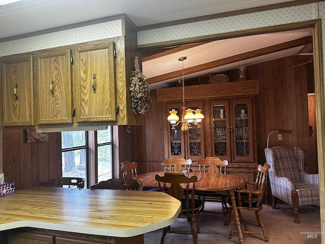 dining area with carpet floors, wooden walls, and a notable chandelier