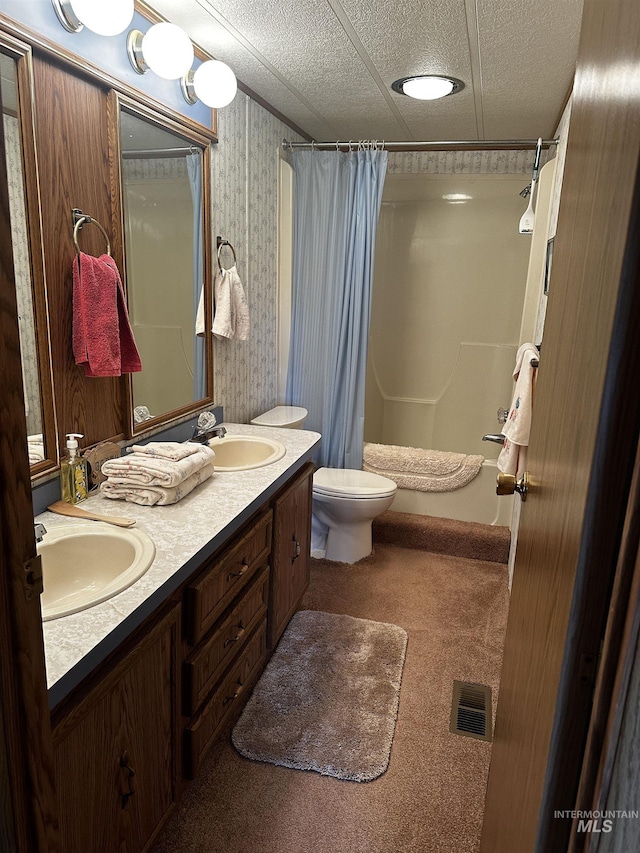 bathroom with a shower with curtain, vanity, a textured ceiling, and toilet