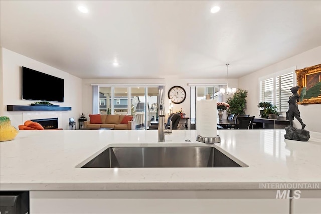 kitchen featuring light stone counters, sink, and plenty of natural light