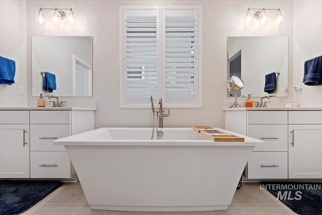 bathroom featuring vanity, tile patterned floors, and a tub