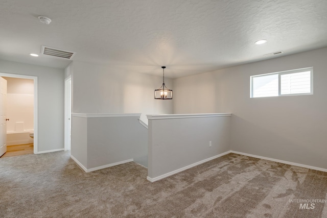 2853 N Eagle Meadow Ave, Kuna, ID 83634 - unfurnished room with an inviting chandelier, light colored carpet, and a textured ceiling