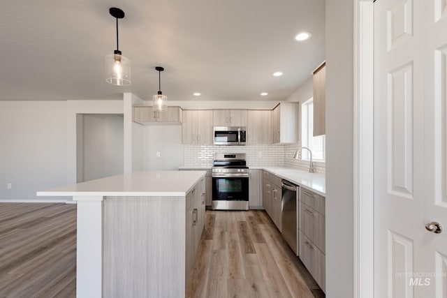 2853 N Eagle Meadow Ave, Kuna, ID 83634 - kitchen with sink, decorative light fixtures, appliances with stainless steel finishes, a kitchen island, and decorative backsplash