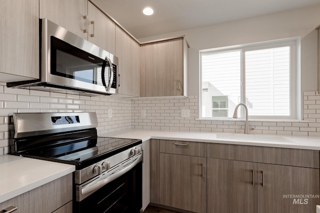 2853 N Eagle Meadow Ave, Kuna, ID 83634 - kitchen featuring stainless steel appliances, light brown cabinetry, sink, and decorative backsplash