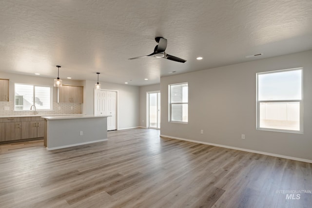 2853 N Eagle Meadow Ave, Kuna, ID 83634 - unfurnished living room with ceiling fan, a textured ceiling, and light wood-type flooring