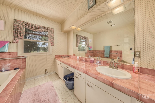 2371 SW 2nd Ave, Ontario, OR 97914 - bathroom with vanity, a relaxing tiled tub, tile patterned floors, and wallpapered walls