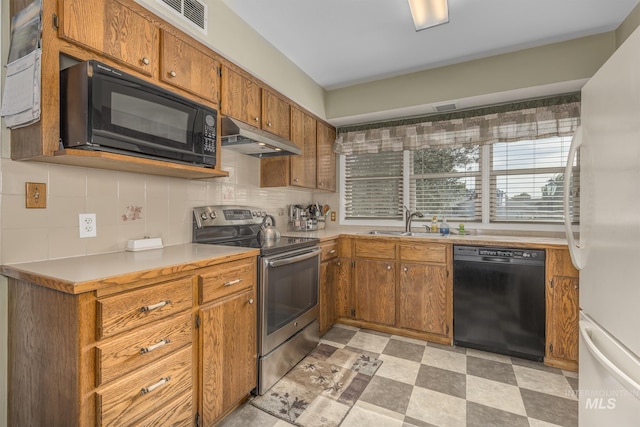 2371 SW 2nd Ave, Ontario, OR 97914 - kitchen featuring black appliances, under cabinet range hood, brown cabinets, decorative backsplash, and light countertops