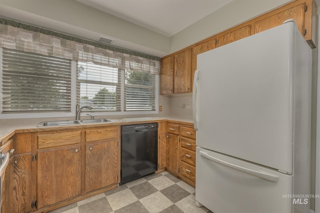 2371 SW 2nd Ave, Ontario, OR 97914 - kitchen featuring freestanding refrigerator, black dishwasher, a sink, and brown cabinets