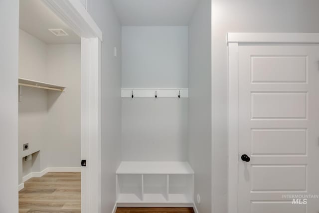 mudroom with baseboards, visible vents, and wood finished floors