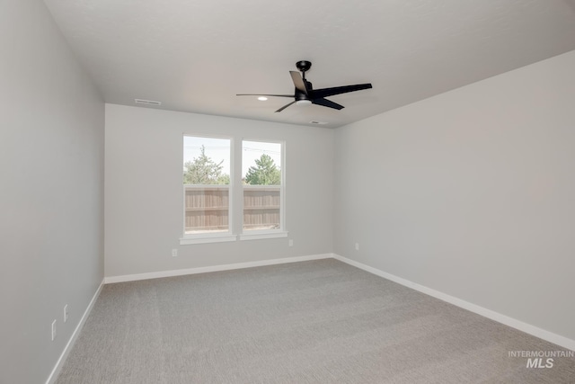 unfurnished room featuring carpet flooring, visible vents, baseboards, and a ceiling fan