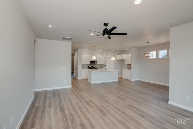 unfurnished living room featuring baseboards, visible vents, and recessed lighting