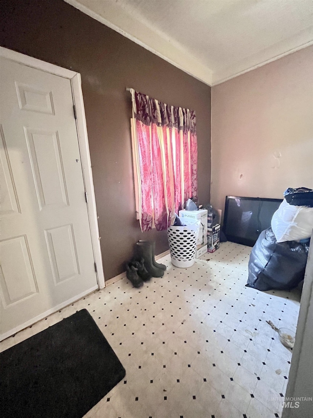 foyer with tile patterned floors and crown molding