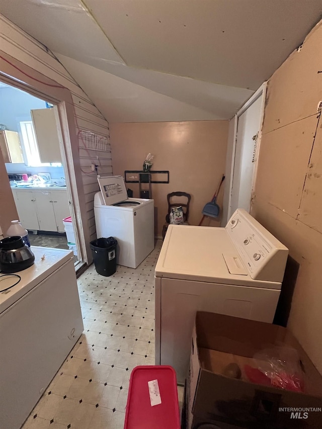 washroom with light floors, laundry area, and washing machine and dryer