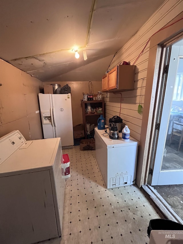 laundry area with washer / dryer, light floors, and wooden walls