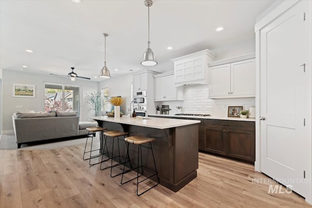 4153 E Raincloud Ln, Boise, ID 83716 - kitchen with gas cooktop, light countertops, a kitchen breakfast bar, open floor plan, and decorative backsplash
