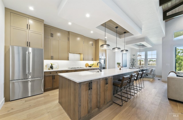 3496 W Parodin St, Eagle, ID 83616 - kitchen with appliances with stainless steel finishes, light wood-type flooring, light countertops, a kitchen island with sink, and a sink