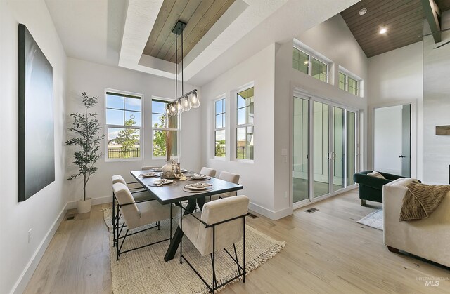 3496 W Parodin St, Eagle, ID 83616 - dining area with baseboards, light wood finished floors, a chandelier, and a towering ceiling
