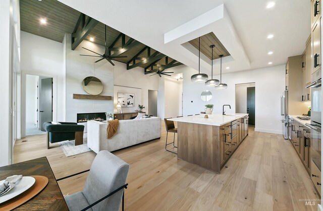 3496 W Parodin St, Eagle, ID 83616 - kitchen with open floor plan, a ceiling fan, a towering ceiling, a kitchen bar, and light countertops