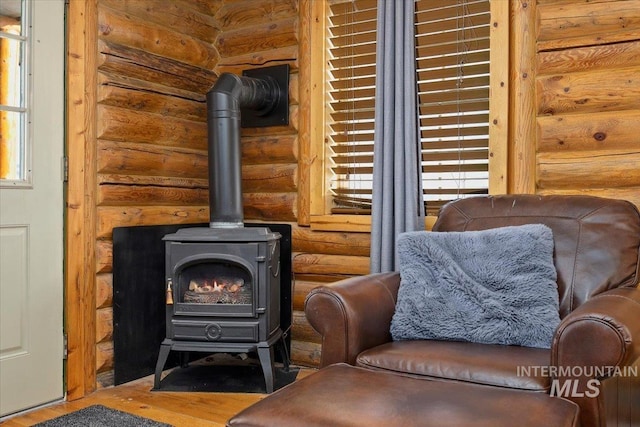 sitting room with hardwood / wood-style flooring and a wood stove