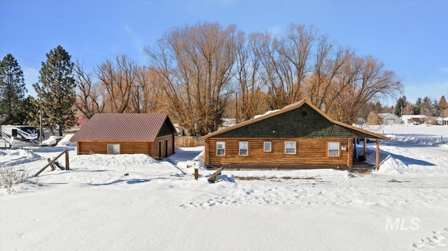 view of snow covered back of property