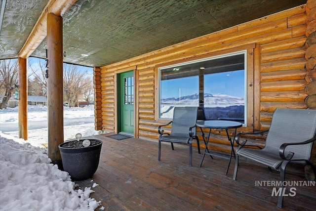 snow covered patio with a mountain view